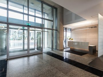 Automatic glass pedestrian doors in a modern commercial building lobby