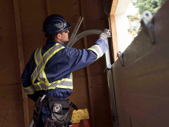 CDS technician inspecting a garage door track during maintenance