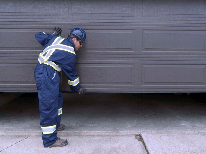 CDS technician inspecting garage door weatherstripping