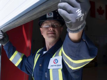 CDS technician inspecting sectional steel door weatherstripping