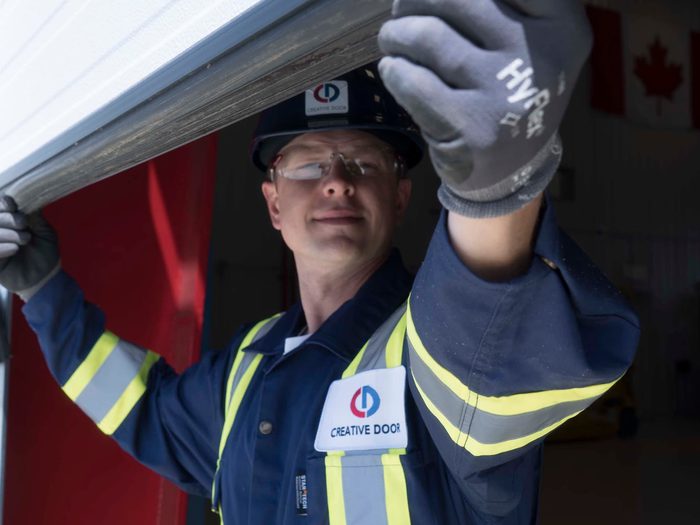 CDS technician inspecting sectional steel door weatherstripping