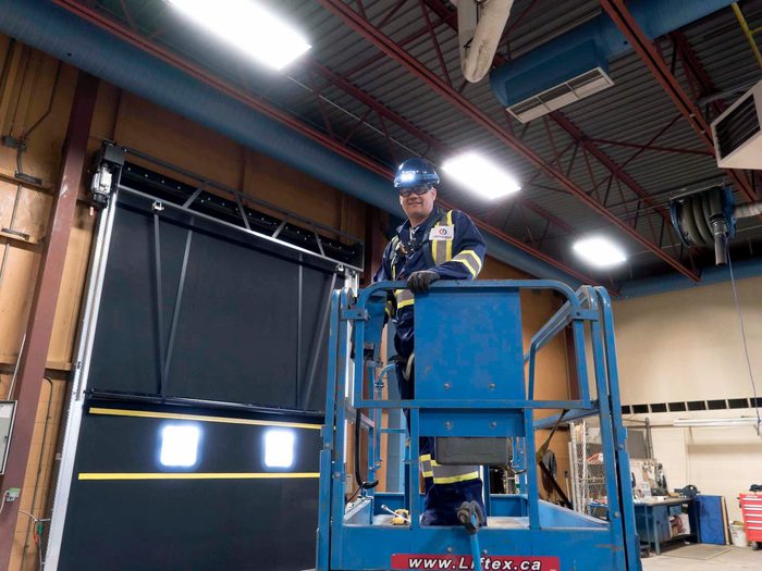 CDS technician on forklift servicing high performance door for heavy industrial facility