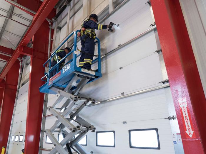 CDS technicians on forklift repairing commercial sectional door