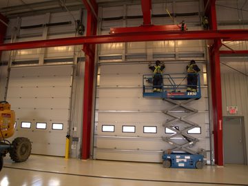 CDS technicians performing planned maintenance on commercial overhead doors in an industrial facility