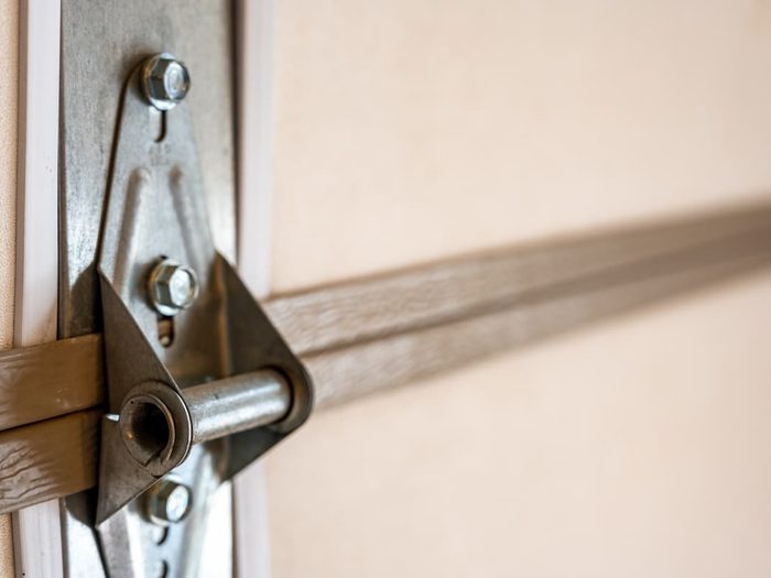 Closeup of garage door metal hinge on panels