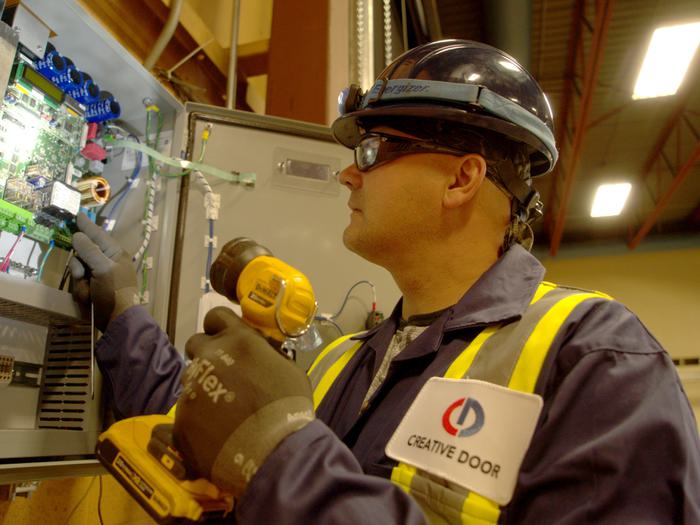 Creative Door Services technician inspecting commercial door controls