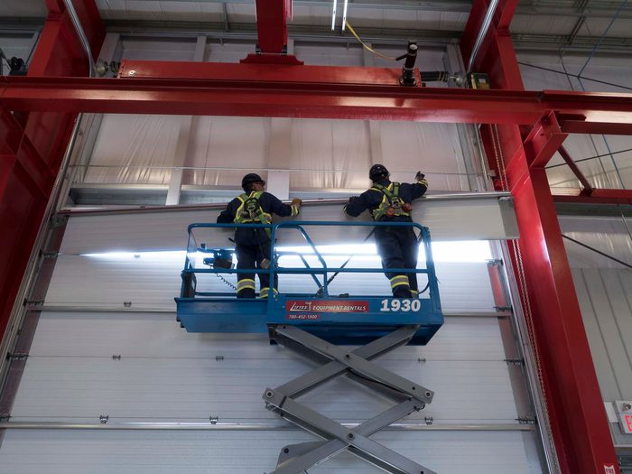 Creative Door Services technicians installing a commercial sectional door