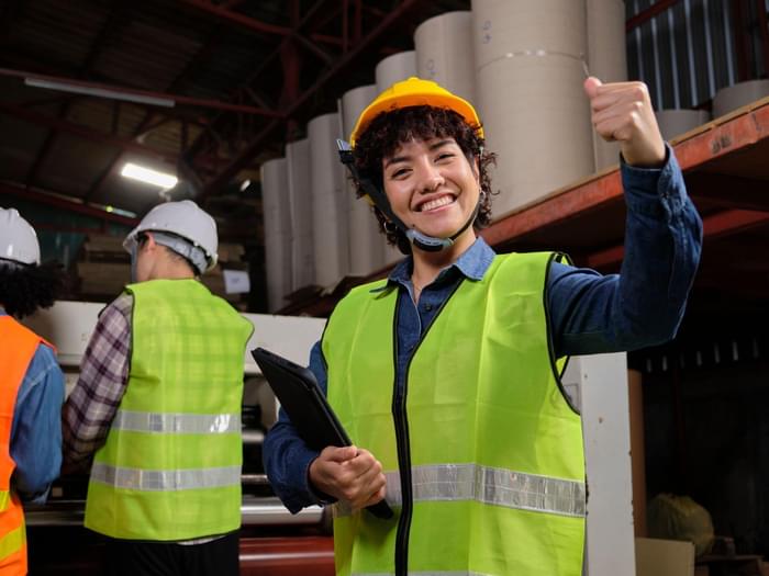Female Technician In Warehouse Thumbs Up Min