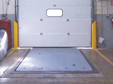 Loading dock entrance with mechanical pit leveler