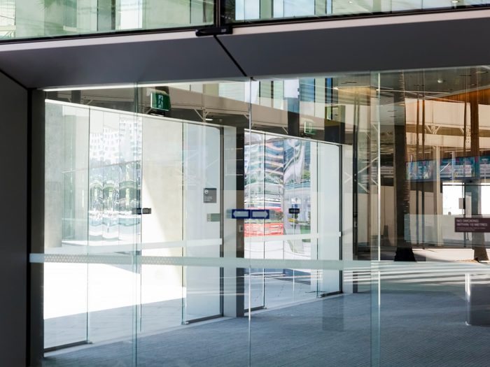 Modern glass pedestrian door at an office building entrance with automatic access system