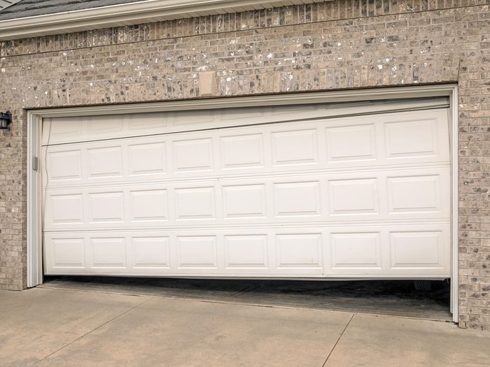 Broken garage door damaged by vehicle collision