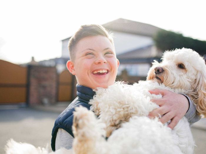 Child Holding Dog In Driveway Min