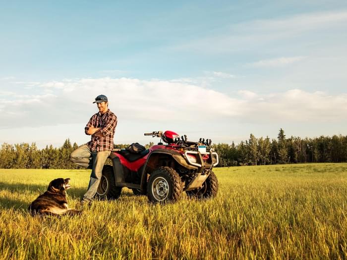 Man In Field With Atv And Dog Min