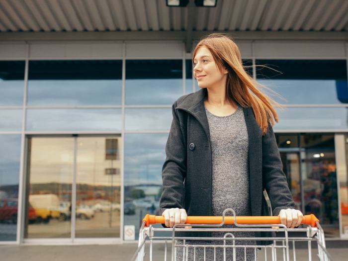 Shopper with grocery cart exiting mall with automatic doors