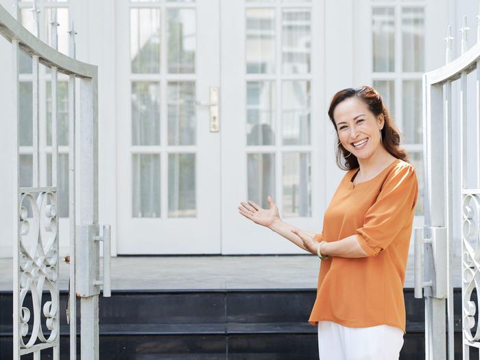 Smiling Welcoming Woman Home Gate Min