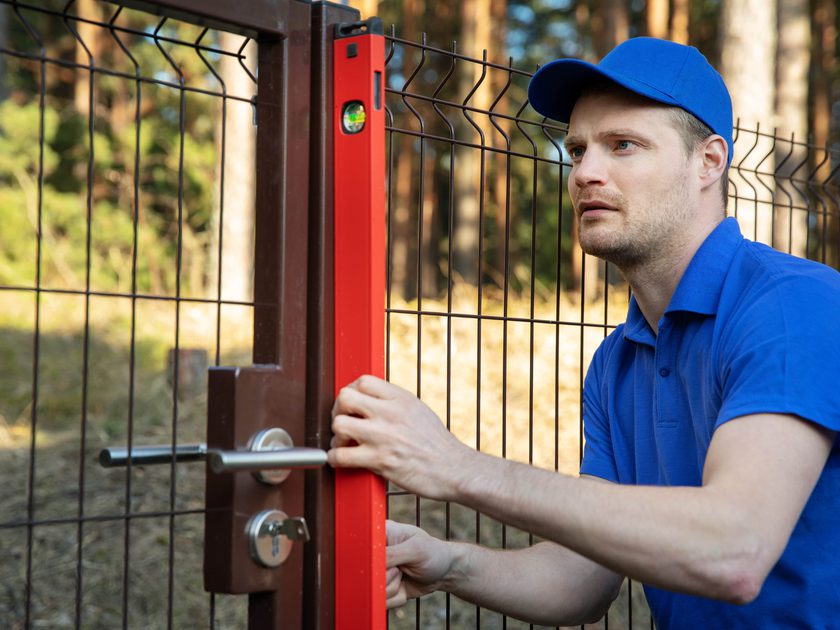 Technician checking level of gate post 1