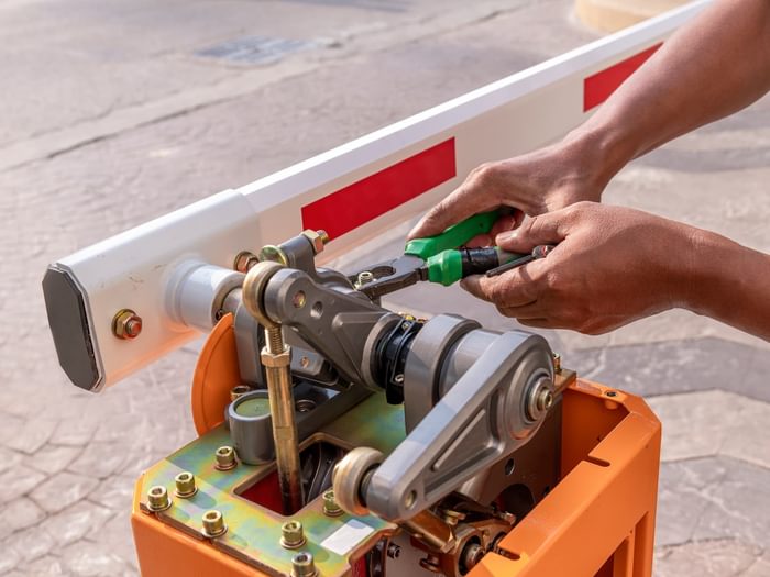 Technician repairing barrier gate arm