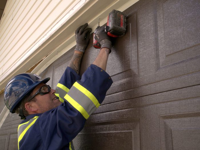 Tecnician Installing Garage Door